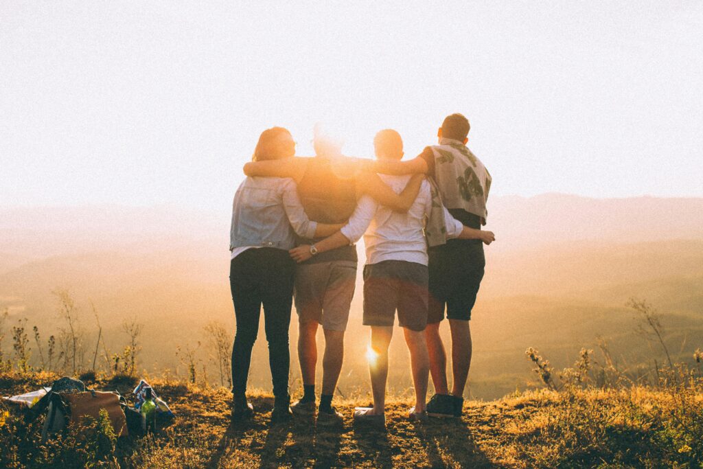 A group of friends embrace while enjoying a breathtaking sunrise over the Brazilian highlands.